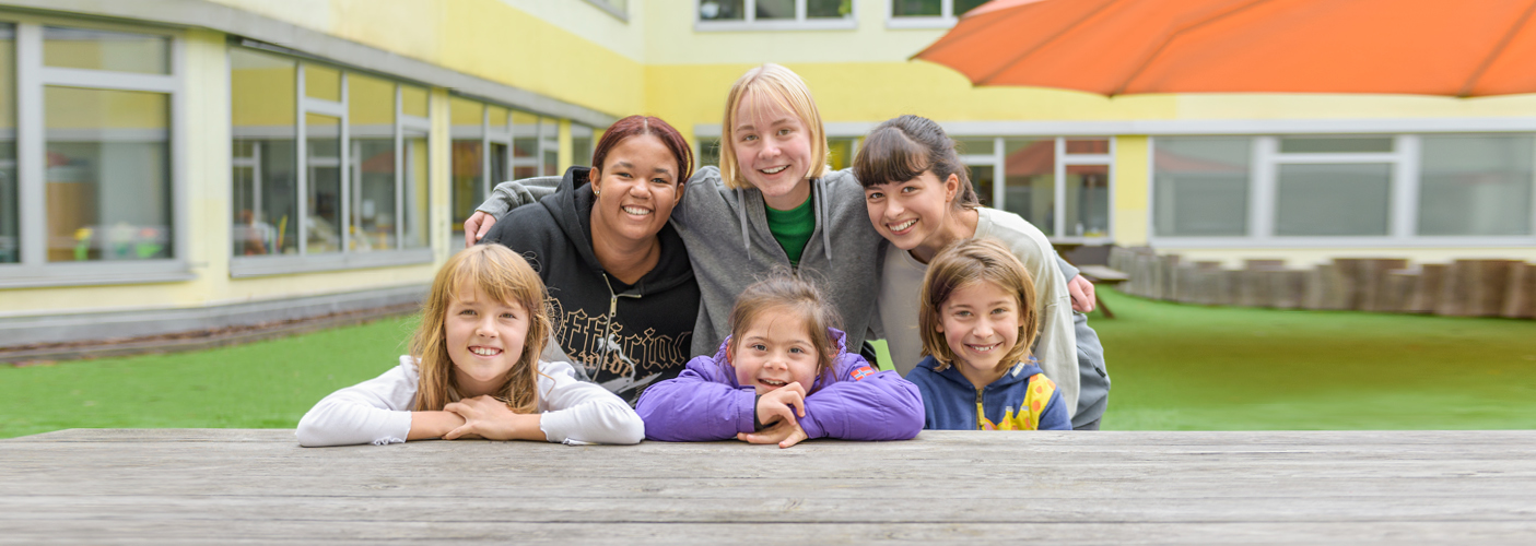 Sechs junge Personen lachen Richtung Kamera