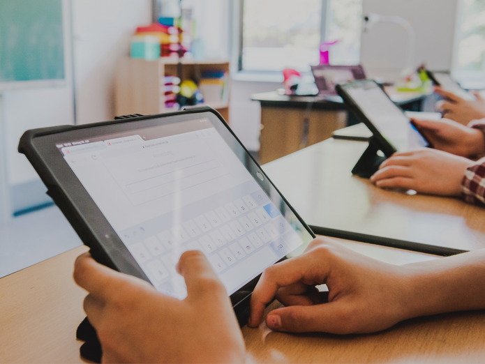 Hände die ein Tablet bedienen