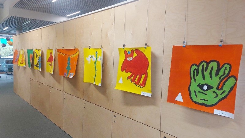 Ein Teil der Kunstwerke, die während der Thementage entstanden sind, hängen nebeneinander an einer Wand. 
